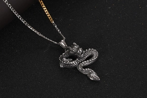 Detailed close-up of a vintage steel dragon pendant necklace with intricate scales