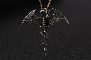 Close-up of gothic dragon wrapped around sword pendant with vintage silver finish