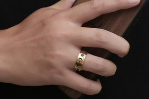 Detail shot of golden titanium ring featuring engraved sun moon and star celestial motifs