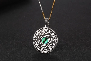 Macro view of vintage titanium steel necklace with green evil eye and zodiac symbols