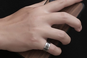 Détail d'une bague en titane pour homme avec rayures noires en scène réelle