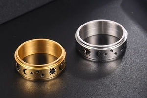 Macro shot of titanium steel spinner rings with sun star and moon engraved patterns