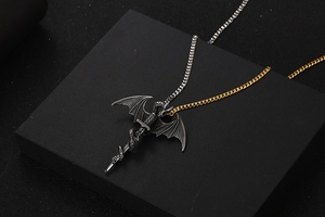 Detailed dragon and sword pendant close-up with bi-color metal chain in silver and gold