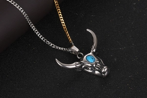 Vue macro du pendentif tête de taureau vintage avec pierre turquoise et chaîne bicolore