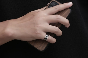 Détail macro d'une bague en titane pour homme avec rainures noires et fini argenté