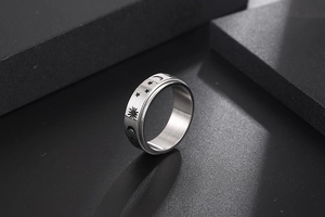 Macro shot of silver titanium ring featuring engraved sun moon and stars celestial patterns