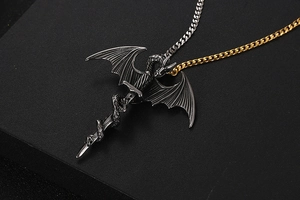 Macro detail of gothic pterosaur sword pendant with dual-tone silver and gold chain