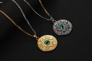 Close-up of dual-tone zodiac rune pendant with green stone inlay and star design