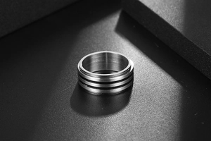 Détail de la bague en acier titane pour hommes avec trois rainures noires et métal brossé