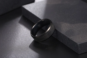 Detailed view of the dark matte titanium ring with snake skin texture and knurled grid pattern