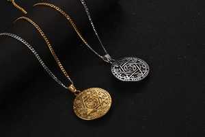 Detail showing two-tone astrological hexagram pendants on black jewelry display stand