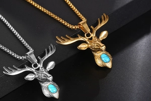 Close-up of gold and silver deer head pendants with turquoise on black display