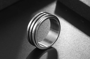 Détail macro d'une bague en titane pour homme avec finition brossée et rayures noires