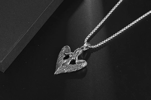 Vue macro d'un pendentif cœur ailes d'ange en argent rétro avec texture de plumes