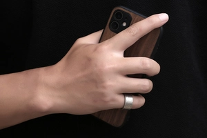 Close-up of a wide titanium steel ring with vintage rock texture on a finger