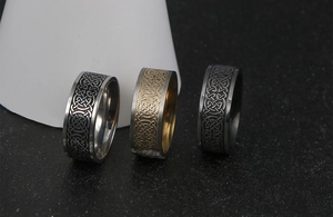 Macro view of men's wide Celtic knot rings in gold, silver, and black stainless steel