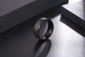 Macro shot of black titanium ring featuring intricate cross-grid texture and industrial style