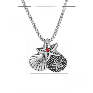 Detailed view of starfish and shell pendant with measurements and red gemstone