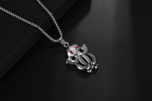 Detail view of octopus pendant with red gemstone eyes and stainless steel chain