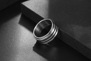 Détail macro d'une bague en titane pour homme avec fini brossé et rayures noires