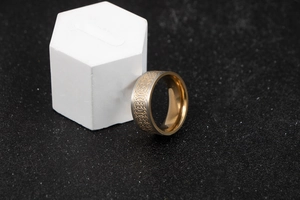 Detailed close-up of two-tone stainless steel ring with golden Celtic knot patterns
