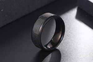 Macro detail of matte black titanium steel ring with textured diamond-cut grid pattern
