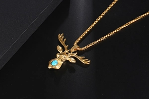 Macro detail of golden deer head pendant with blue turquoise gemstone on pearl chain