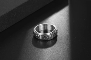 Macro detail of Nordic Runes relief on vintage stainless steel ring with inner brushed finish