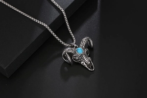 Macro detail of gothic ram skull pendant with turquoise stone and vintage steel texture