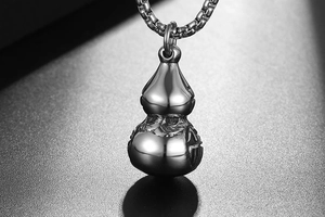 Macro view of silver stainless steel gourd pendant with Fu character and box chain detail