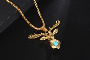 Macro shot of gold deer head pendant with blue turquoise stone and box chain detail