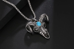 Macro detail of gothic bull skull pendant with blue stone inlay and vintage finish