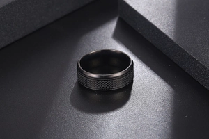 Macro shot of titanium ring with textured cross-grid pattern on geometric background