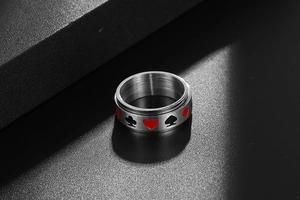 Gros plan d'une bague rotative en acier inoxydable avec motifs de poker et métal brossé