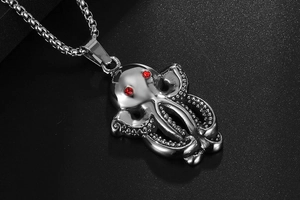 Close-up of titanium steel octopus pendant with red gemstone eyes and silver box chain