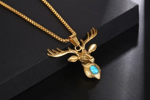 Close-up of golden stag pendant with turquoise stone inlay on a box chain