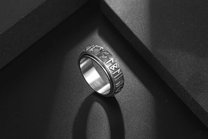 Macro shot of rotating stainless steel ring featuring vintage Nordic rune engravings