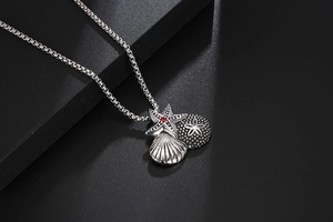 Close-up of vintage starfish and seashell charms on a polished stainless steel chain