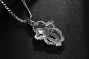 Detail of vintage silver octopus pendant with box chain and polished back surface