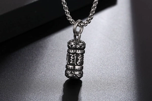Macro detail of vintage titanium steel necklace with lotus relief and engraved symbols