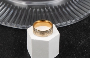 Detail showing two-tone Celtic knot relief and polished golden inner band on a ring