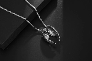 Détail du pendentif aile d'ange en argent avec texture de plumes sur chaîne en acier vintage