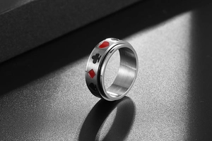 Gros plan sur une bague rotative en acier avec motifs de poker cœur et pique gravés