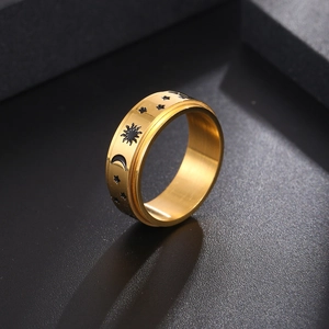 Titanium steel spinner ring with black sun moon stars motifs on a golden band