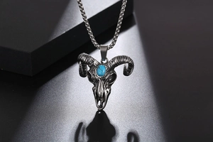 Detail of ram skull pendant with blue turquoise stone inlay on a dark box chain