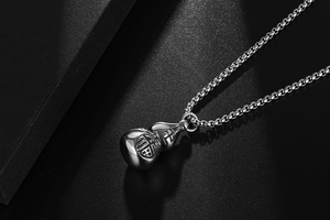 Detailed macro shot of vintage stainless steel gourd pendant with Fu character and box chain