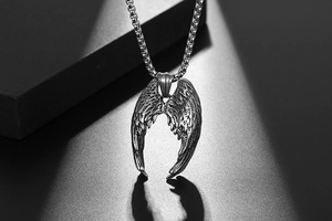 Gros plan détaillé du pendentif ailes d'ange en acier titane au style vintage