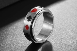 Gros plan d'une bague rotative en acier titane brossé avec motifs de cartes de poker