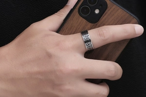Gros plan d'une bague vintage pour homme en acier titane avec motifs celtiques noirs et argentés