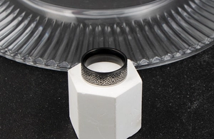Close-up of black and silver men's ring featuring intricate Celtic knot pattern